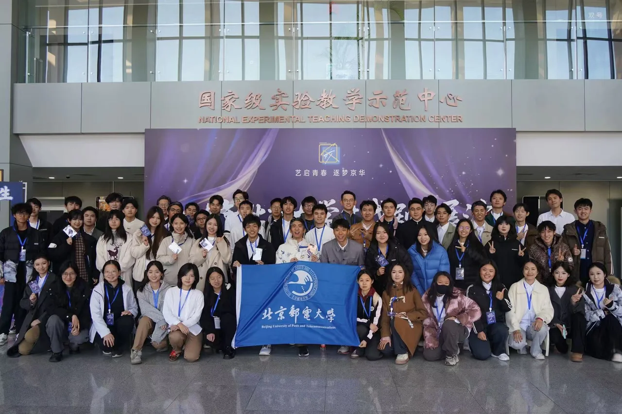 剧组在国家级实验教学示范中心前合影,前排展开北京邮电大学校旗