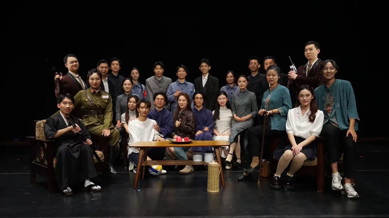 《寻找李白》剧组在舞台上合影，大家站在或坐在沙发与茶几周围